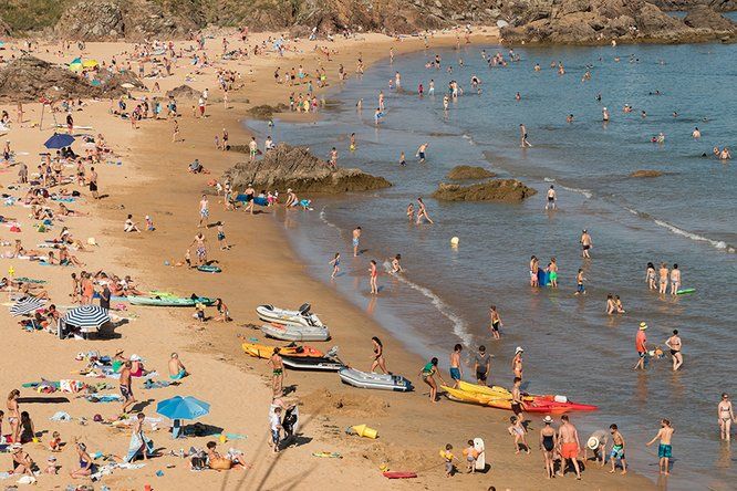 plage noire de vacanciers en été